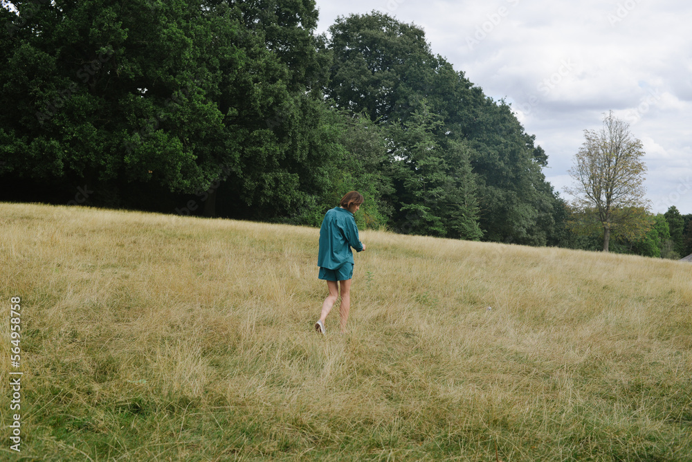 A lonely woman walking in a field A lonely woman walking in a field