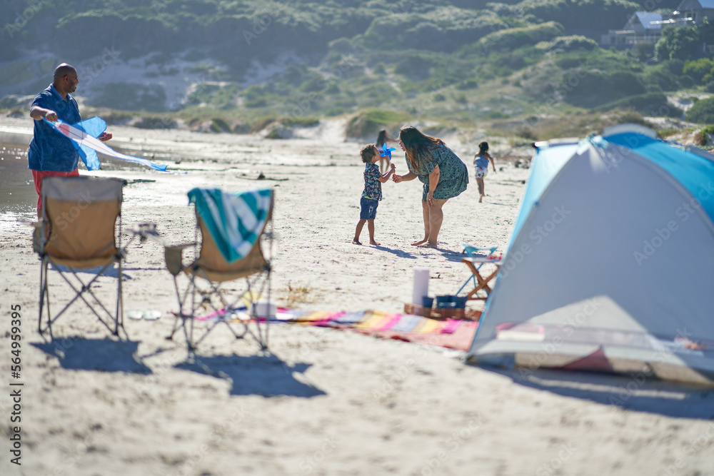 Family playing with kite and pinwheel on sunny beach Family playing with kite and pinwheel on sunny beach