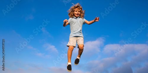 Caucasian boy in a park running and smiling on blue sky. Happy kid laughing. Emotion face joy child. Joyful, funny spring, summer day, outdoors. Spring and kid. Banner for website header.
