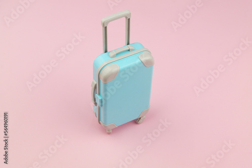 Suitcase on pink background with room for text. Travel and baggage concept.