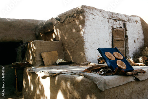 Loafs of Bread in Front of Adobe Home