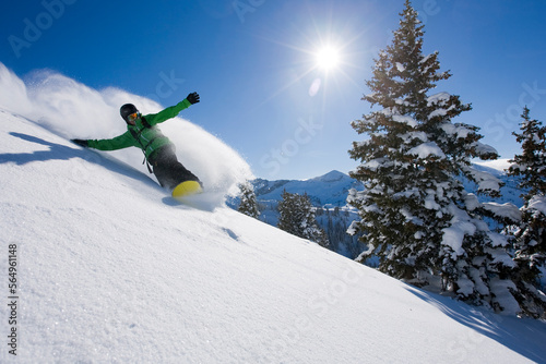 A snowboarder making some fresh tracks on a sunny day in Utah.