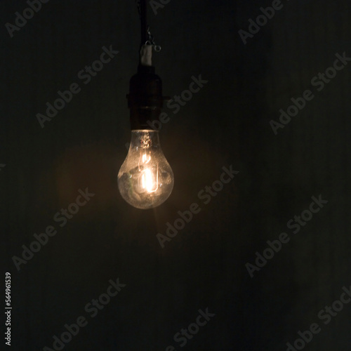 A lit, bare hanging light bulb.