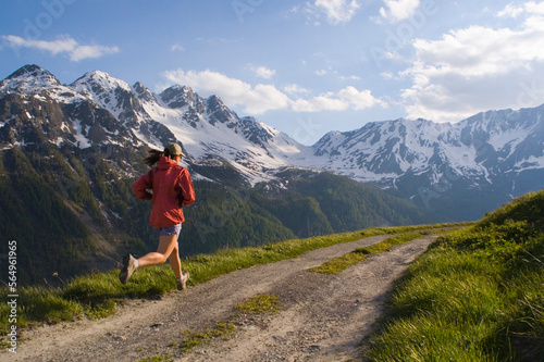 A woman running on a dirt road in Courmayer Italy photo