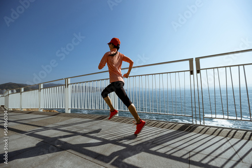 Fototapeta Naklejka Na Ścianę i Meble -  Healthy lifestyle fitness sports woman runner running up stairs on seaside trail