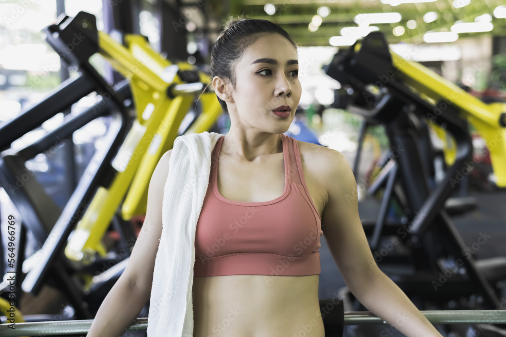 Sportswoman with towel on shoulder relax after doing hard exercise in gym, woman Fitness Concept Sportswoman with towel on shoulder relax after doing hard exercise in gym, woman Fitness Concept