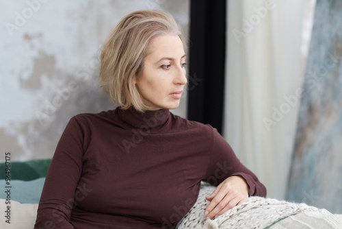 portrait of sad middle aged woman relaxing at home. banner. easonal affective disorder photo