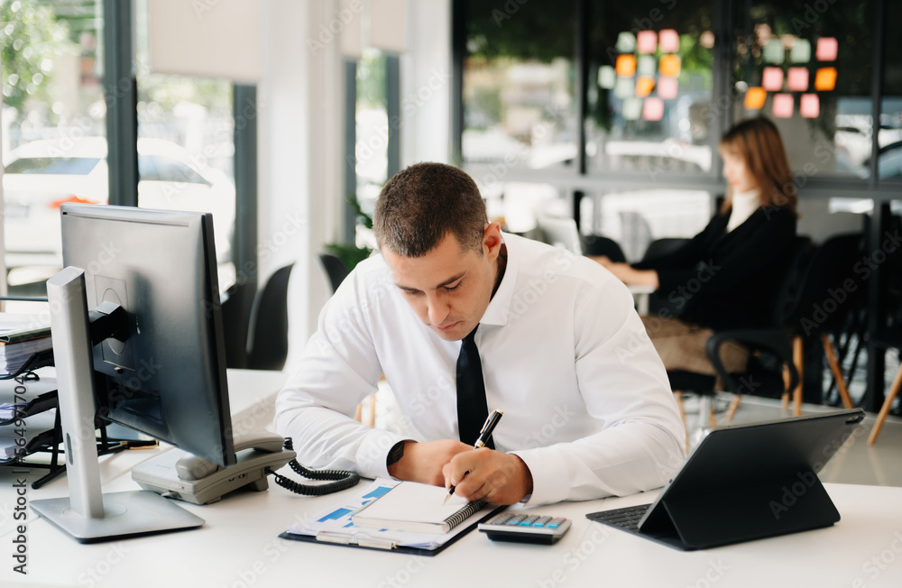 Asian businessman working in the office with working notepad, tablet and laptop documents at office Asian businessman working in the office with working notepad, tablet and laptop documents at office