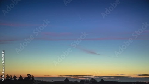 Timelapse Of Comet Moving Shortly After Sunset High In The Blue Sky photo