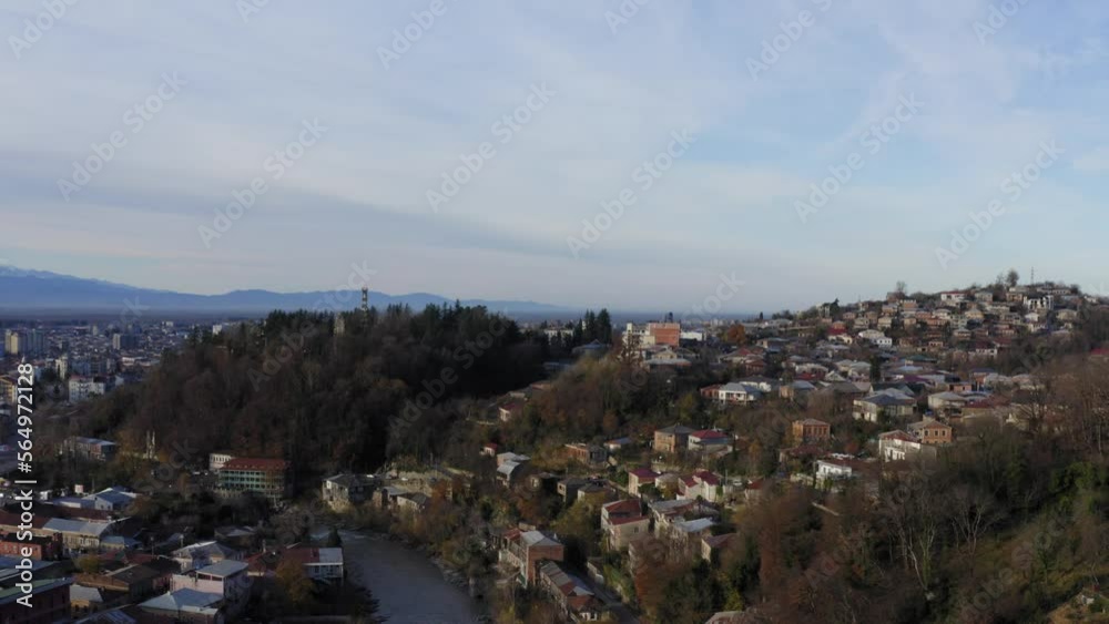 Aerial flying over Kutaisi city with snowy mountains and river Aerial flying over Kutaisi city with snowy mountains and river