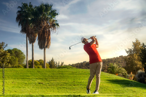 golf shot man. professional golf swing. Golf player teeing off. Front view of golfer finishing swing with a smile. Full length of golfer playing on the course. Golfer hitting golf shot with club photo