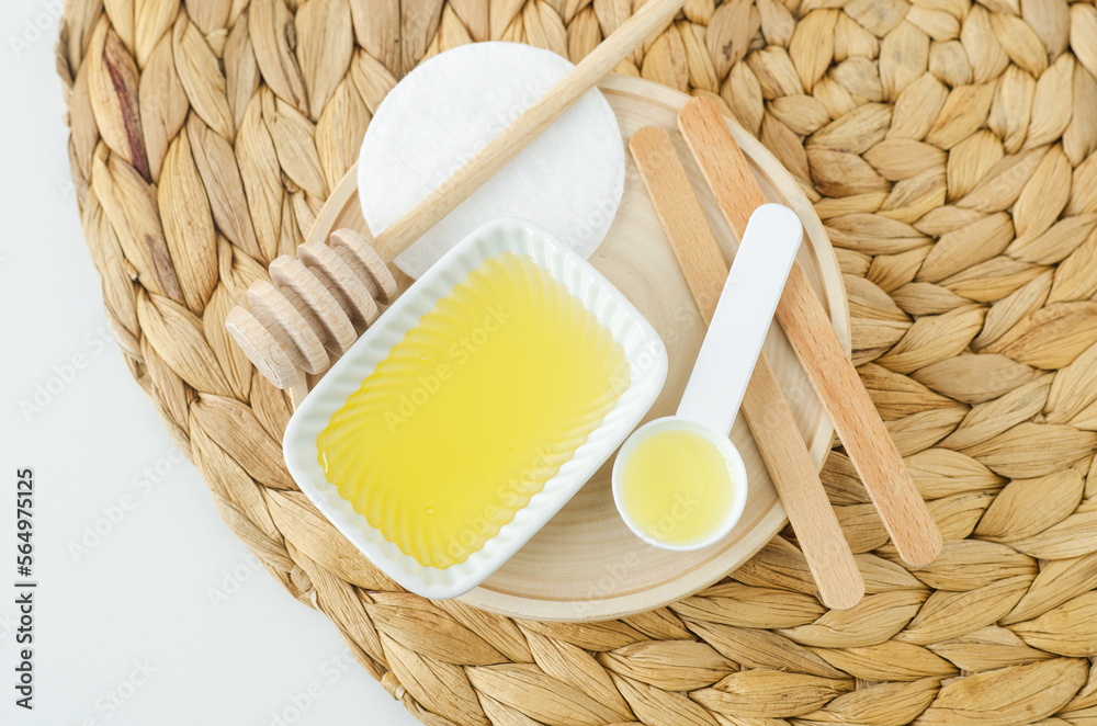 Small bowl with honey and spoon with olive oil. Homemade hair or face mask, natural beauty treatment and spa recipe. Top view, copy space.