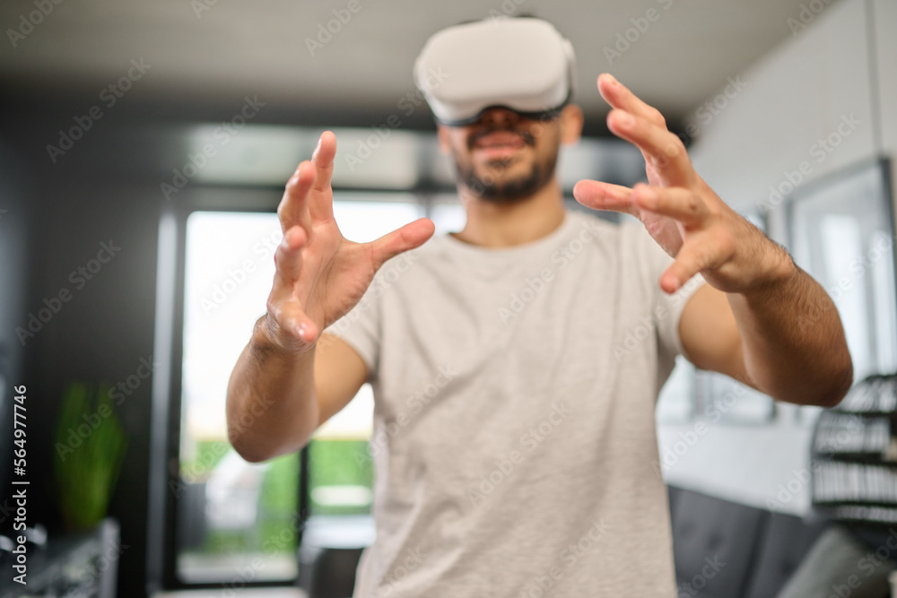 Virtual reality glasses, technology and hands of man in home with headset for interactive, online and 3d games. Futuristic, user interface and male with vr for metaverse, cyberspace and gaming ux Virtual reality glasses, technology and hands of man in home with headset for interactive, online and 3d games. Futuristic, user interface and male with vr for metaverse, cyberspace and gaming ux