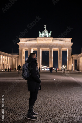 Unrecognizable tourist man in a warm coat with the Brandenburg Gate in the background - tourism and history concept