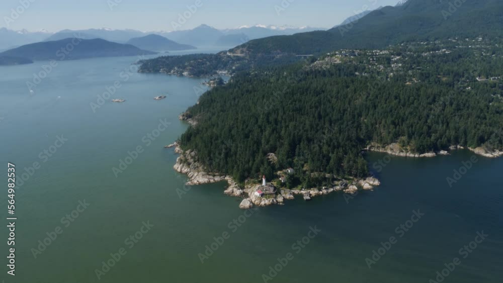 Aerial video shot over the ocean captures the breathtaking beauty of West Vancouver, BC, Canada. The clear blue waters stretch out to the panoramic views of the coastline and mountains. Aerial video shot over the ocean captures the breathtaking beauty of West Vancouver, BC, Canada. The clear blue waters stretch out to the panoramic views of the coastline and mountains.