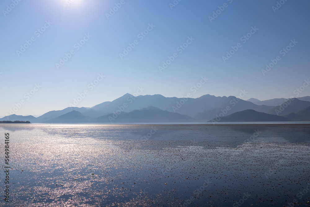 Scenic view on beautiful lake of Skadar National Park on sunny autumn day seen from Vranjina, Bar, Montenegro, Balkans, Europe. Travel destination, Dinaric Alps near Albania. Magical water reflection