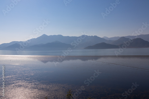 Scenic view on beautiful lake of Skadar National Park on sunny autumn day seen from Vranjina, Bar, Montenegro, Balkans, Europe. Travel destination, Dinaric Alps near Albania. Magical water reflection © Chris