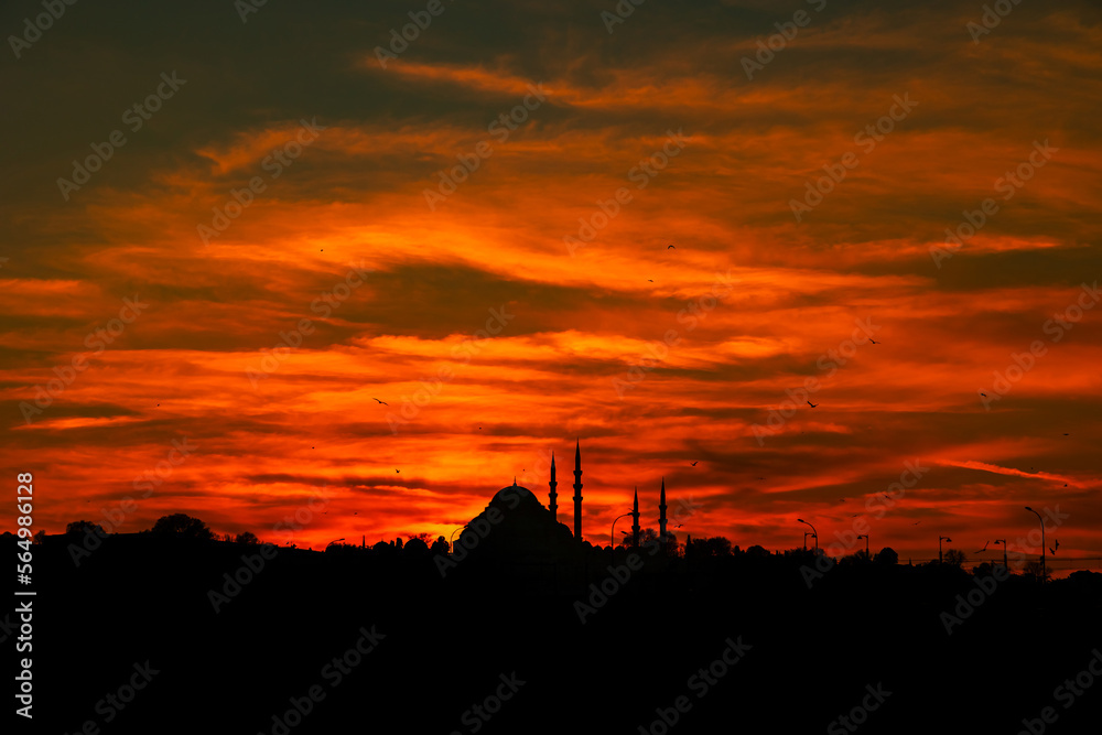 Istanbul at sunset with dramatic orange and red clouds. Silhouette of mosque