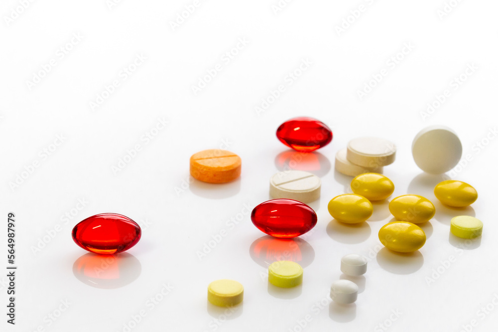 multi-colored pills of vitamins, dietary supplements on a white table close-up multi-colored pills of vitamins, dietary supplements on a white table close-up