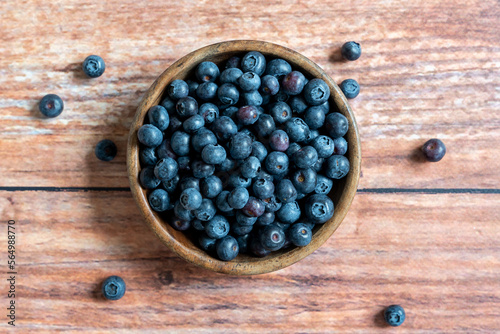 Top down view of a bowl of fresh blueberries on wooden background