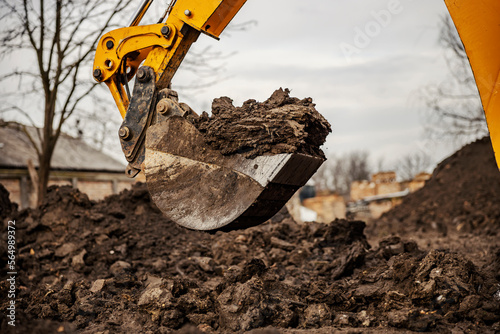 Close up of a earthmover digging soil on construction site. photo