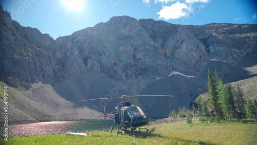 A thrilling helicopter tour of the Canadian Rocky Mountains, breathtaking aerial views of snow-capped peaks, glaciers, rivers, and forests. Wilderness from a bird's-eye view visible from above. photo