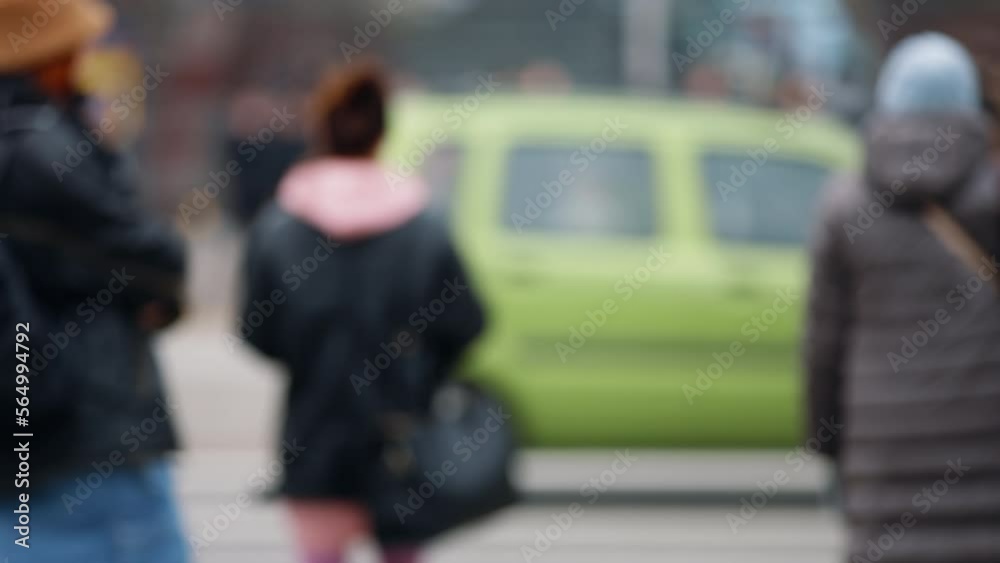 Bokeh blurred urban city life background, traffic city roadway, cars driving crossroad in slow motion. People pedestrians walking down the street, standing on sidewalk waiting for green traffic light Bokeh blurred urban city life background, traffic city roadway, cars driving crossroad in slow motion. People pedestrians walking down the street, standing on sidewalk waiting for green traffic light