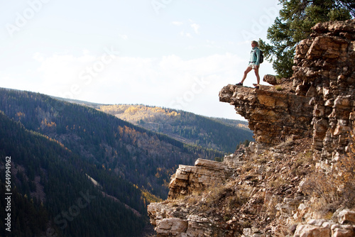 A young woman hiking takes a look over the edge of the canyon. photo