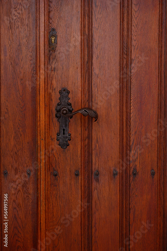 Old handle on a wooden door. beautifully shaped doorknob.