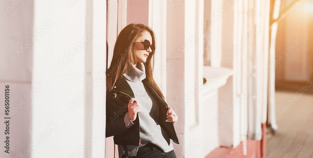 Stylish girl in sunglasses posing on city street passing Stylish girl in sunglasses posing on city street passing