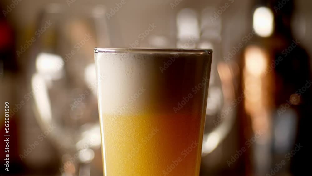 Craft Beer being poured in to a pint glass, light background, close up Craft Beer being poured in to a pint glass, light background, close up