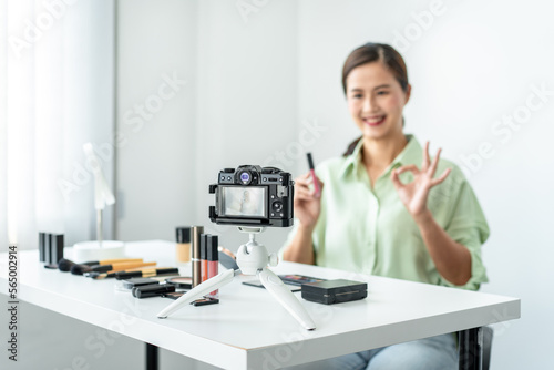Woman blogger is present make up tutorial beauty cosmetic review product and broadcast live streaming video to teaching online on the camera screen at office studio