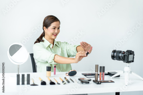 Woman blogger is showing present make up tutorial beauty cosmetic review product and broadcast live streaming video to social network teaching online on the camera screen