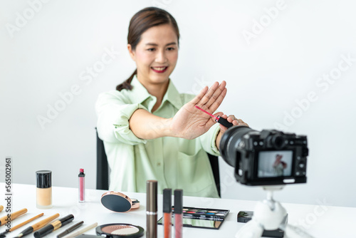 Woman blogger is present make up tutorial beauty cosmetic review product and broadcast live streaming video to teaching online on the camera screen at office studio
