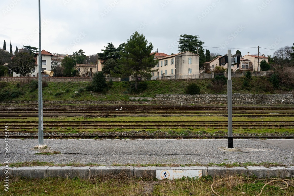 Ales, Occitanie, France, Deserted platform, railways and residential houses in the background