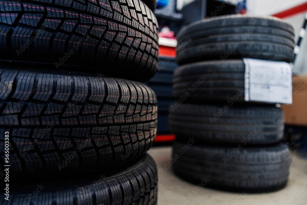 Selective focus on new tires in a mechanic's shop with old ones in blurry background. Selective focus on new tires in a mechanic's shop with old ones in blurry background.