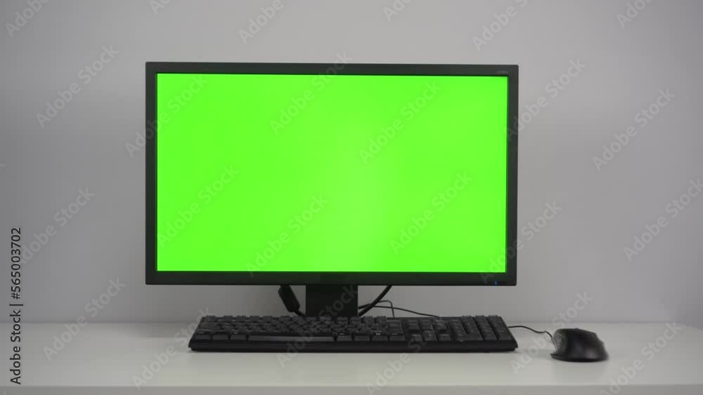 A monitor with a green screen is on the desktop in the office. Chroma Key on PC. The camera is moving away from the object. A monitor with a green screen is on the desktop in the office. Chroma Key on PC. The camera is moving away from the object.