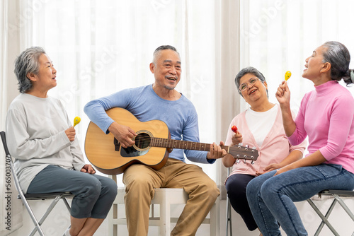 Group of senior peoples enjoy playing guitar and singing together in living room