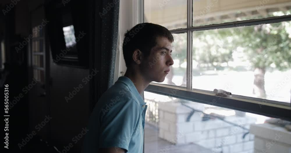 Young man, teenage boy, watches out window. Young man, teenage boy, watches out window.
