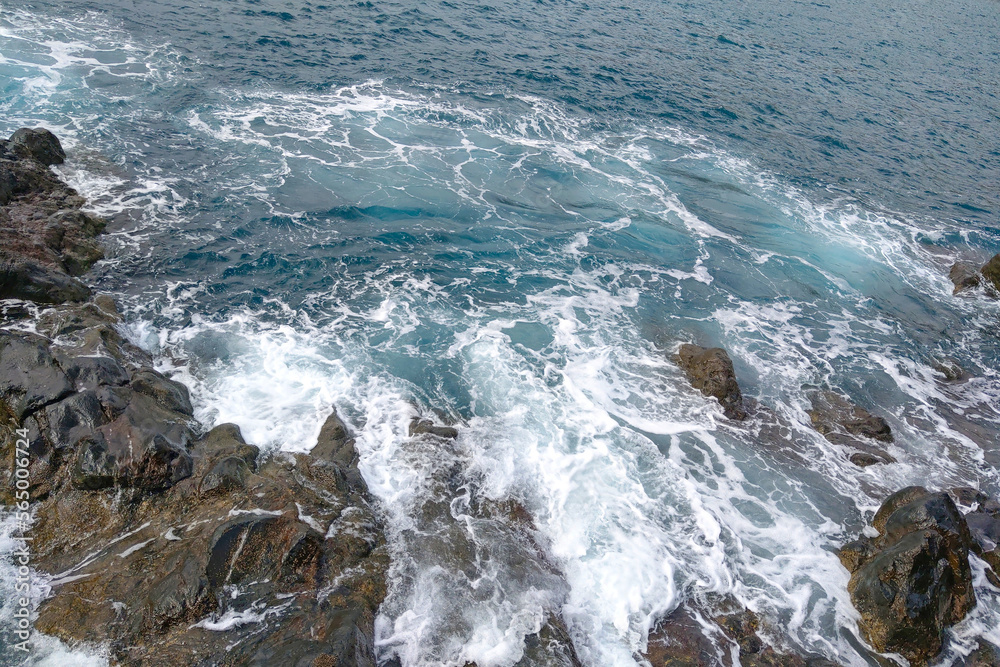 View from a height of turquoise waves against the rocks. View from a height of turquoise waves against the rocks.