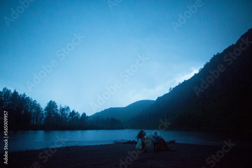 Two women take a moment to reflect as lightning lights up the night sky as the monsoonal storm continues to move further away from camp in northern Mongolia. photo