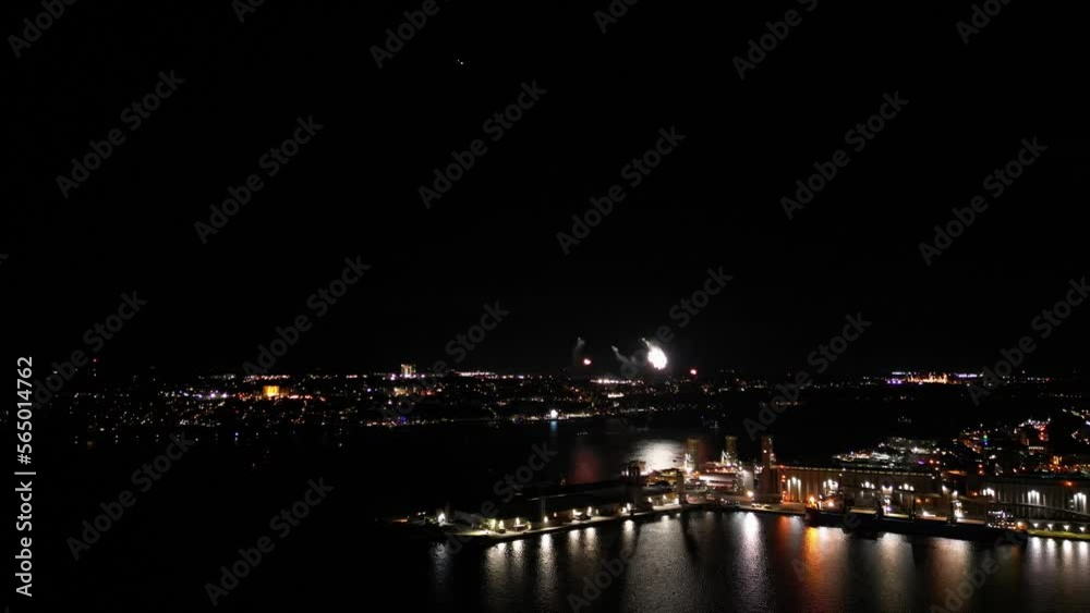 Firework at night over a river, with port Firework at night over a river, with port