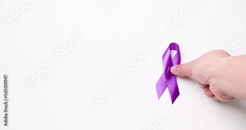 Detail of a male hand holding a light purple ribbon on a white background. Cause ribbons. photo