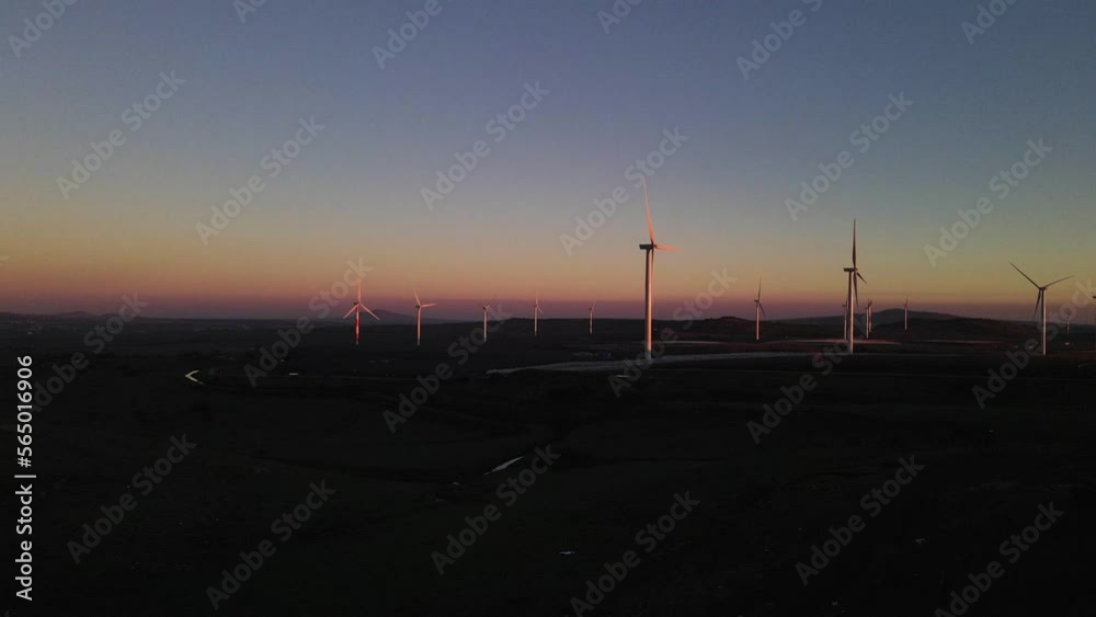 Drone flying towards wind turbines on wind farm at dusk, Valley of Tears, Israel Drone flying towards wind turbines on wind farm at dusk, Valley of Tears, Israel
