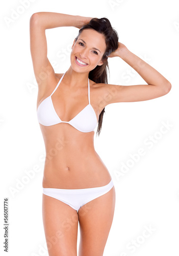 Portrait of a long hair brunette model in a bikini posing with both her hands raised and holding her hair against an isolated PNG background. © peopleimages.com
