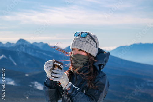 雪山でチョコを食べる女性