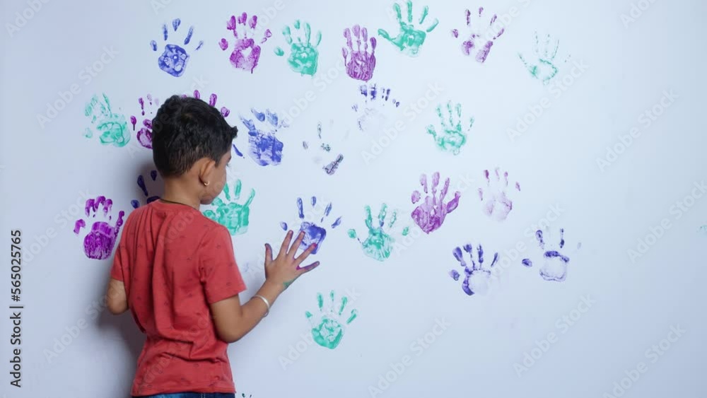 Kid creating mess by handprint paint on white wall - concept of childhood lifestyle, imagination and creativity. Kid creating mess by handprint paint on white wall - concept of childhood lifestyle, imagination and creativity.