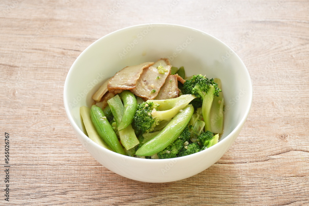 stir fried broccoli with green pea in oyster sauce topping slice grilled pork on bowl