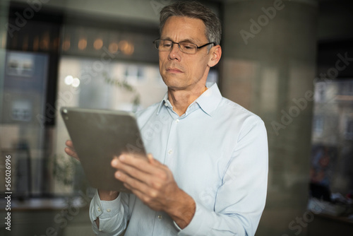 Portrait of successful businessman in office. Man writing on the glass board in office