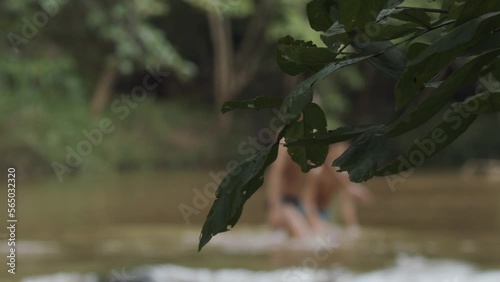 People wading in a shallow river in Brazil - defocused in the background photo